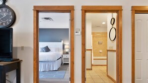 A hotel room with a bed, bedside table, and a clock on the wall. - The Silver Valley Slope - Resort and Hot Tub (Kellogg)
