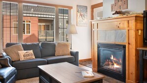 A cozy living room with a fireplace, a sofa, and a coffee table. - The Silver Valley Slope - Resort and Hot Tub (Kellogg)