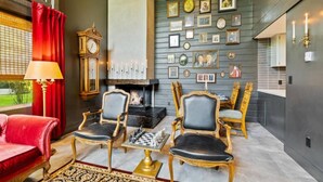 A room with a fireplace, two armchairs, a red sofa, and a chessboard. - Broomsticks, Harry Potter themed BNB, Hot Tub! (Coeur d'Alene)