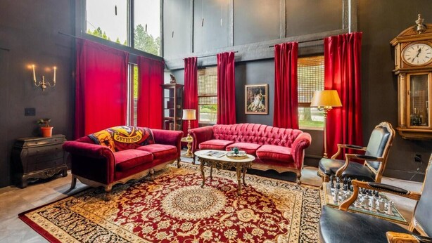 A room with a red sofa, a round coffee table, and a chessboard. - Broomsticks, Harry Potter themed BNB, Hot Tub! (Coeur d'Alene)