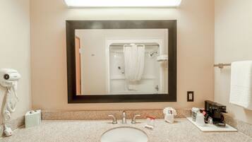 A bathroom with a sink, mirror, towel rack, and a hairdryer.