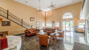 A spacious lobby with a marble floor, leather sofas, and a staircase. - Days Inn & Suites by Wyndham Beeville (Beeville)