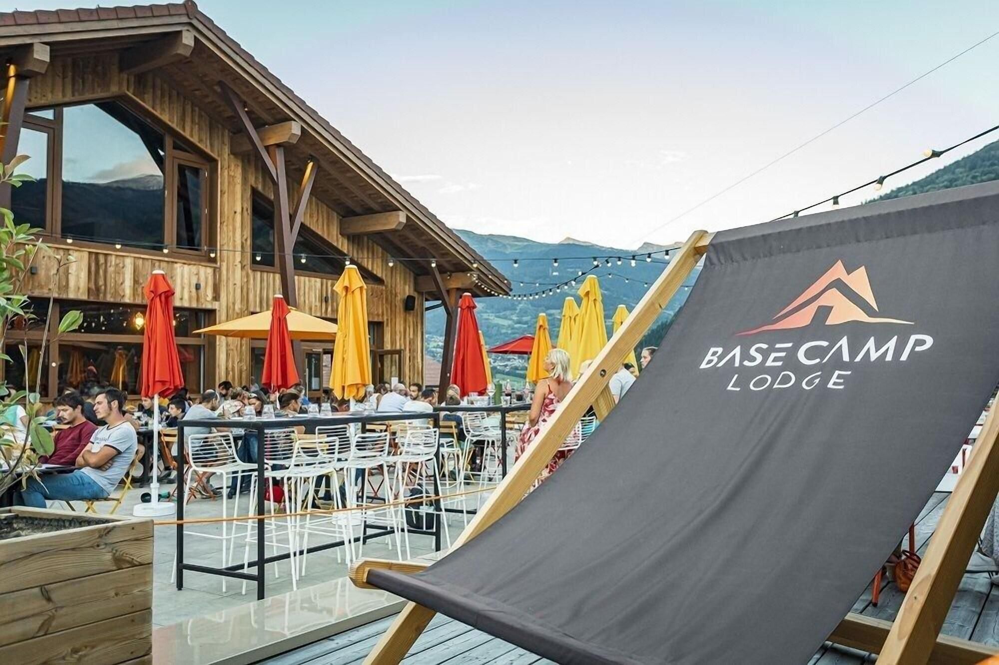 Een houten lodge met terras en uitzicht op bergen.