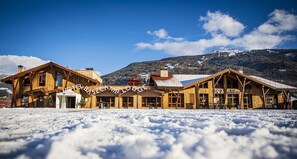 Un chalet en bois doté d’un bar et d’un restaurant, entouré de neige.