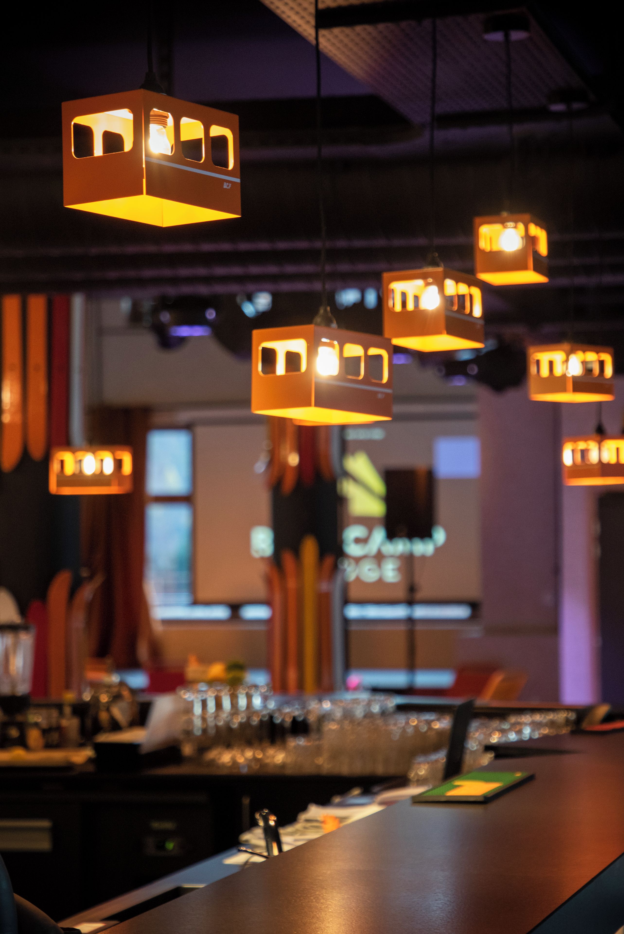Uma área de bar com luminárias pendentes e um balcão.