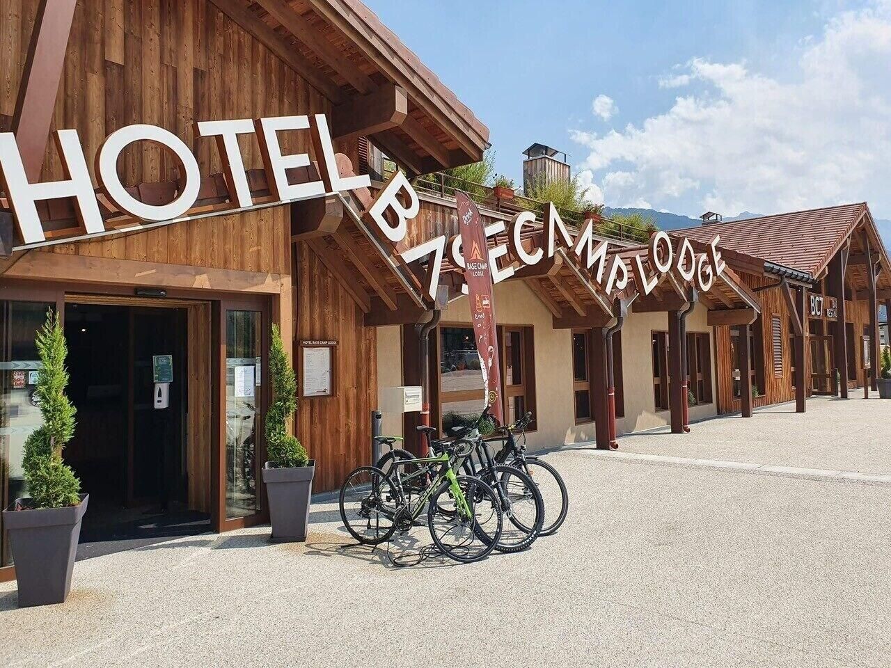 Un hotel de arquitectura de madera, un cartel y bicicletas estacionadas al frente.