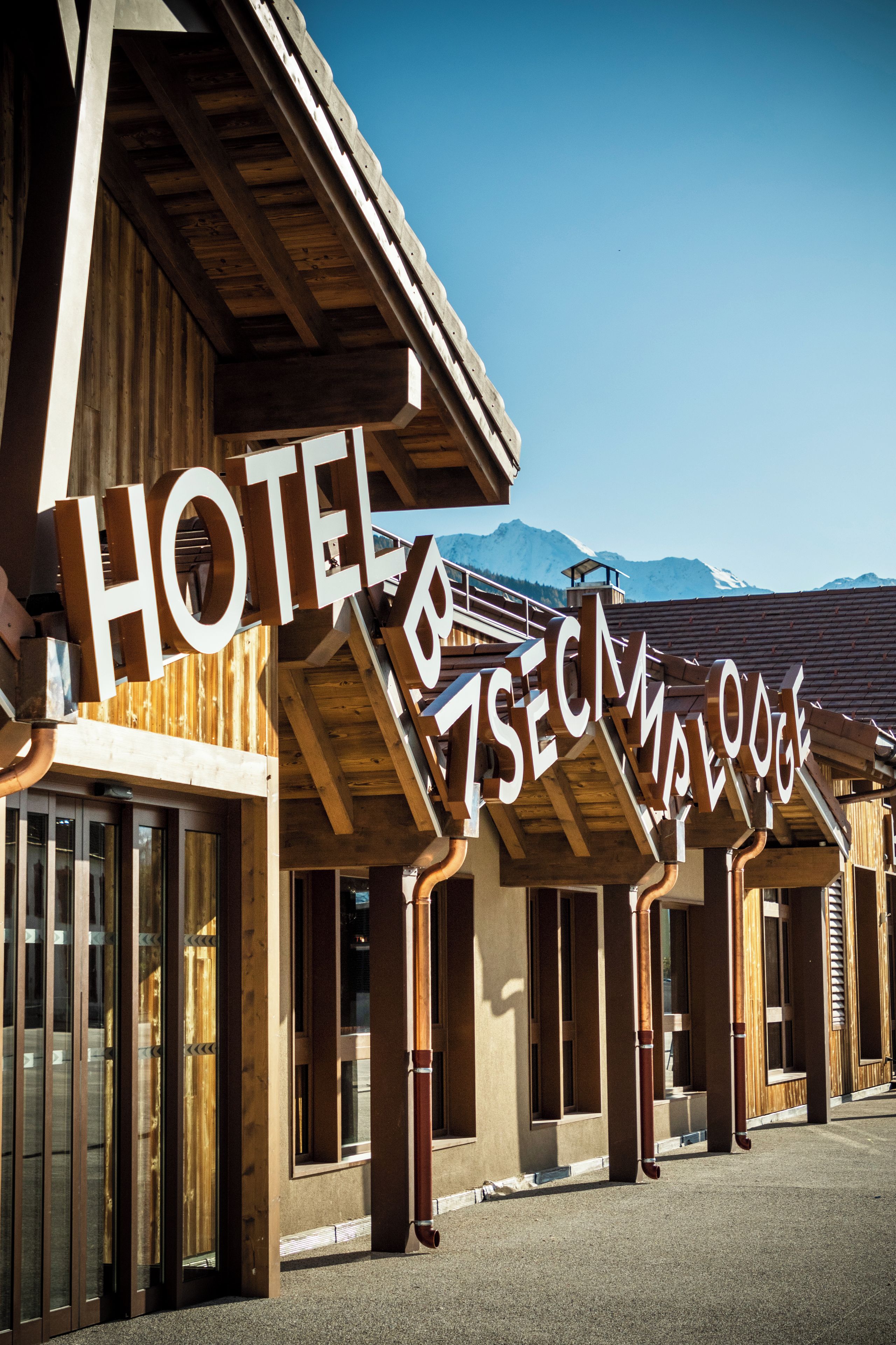 A hotel with a wooden facade and large signage indicating its name.