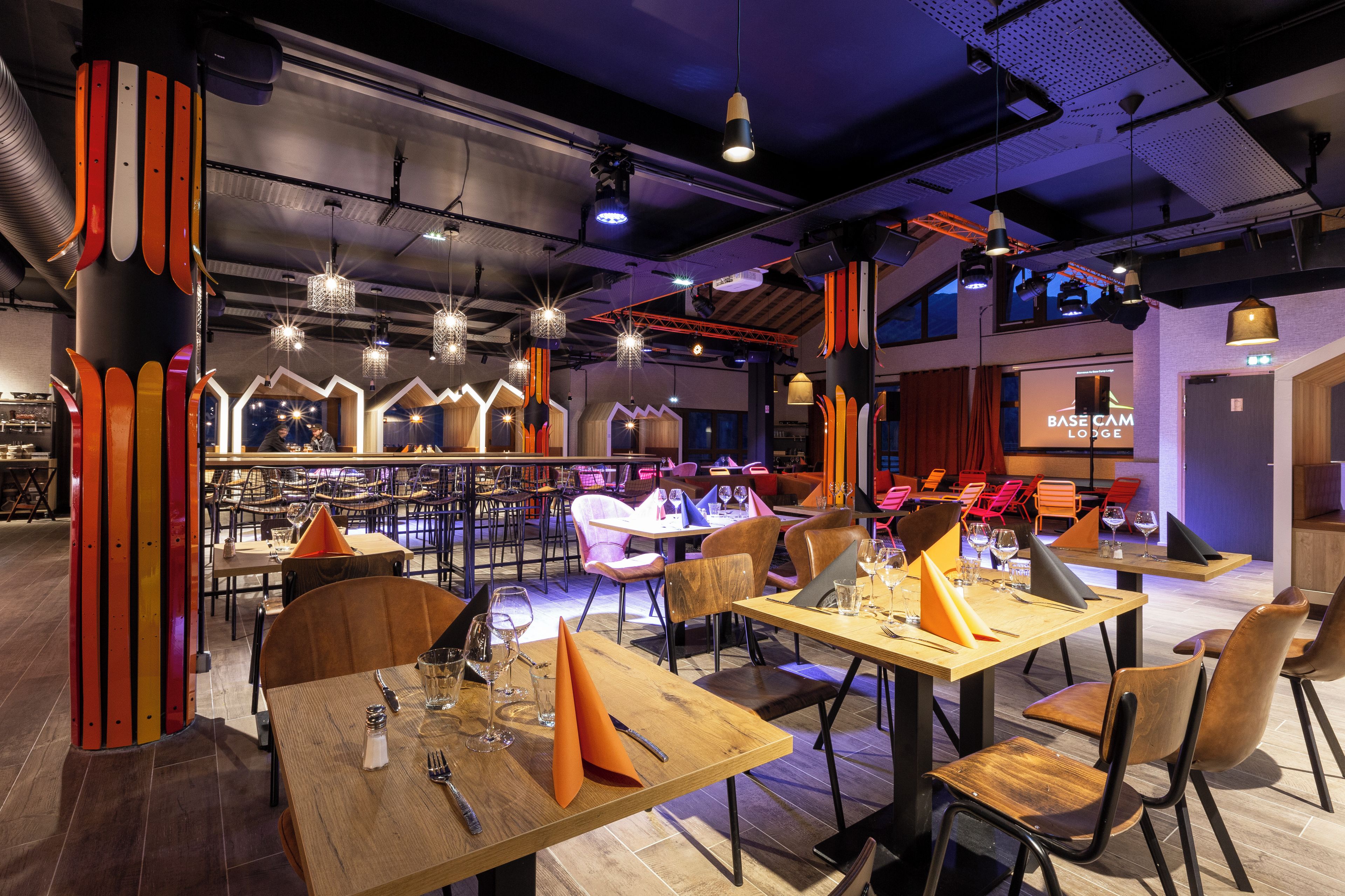 Moderni ravintola, jossa on puupöytiä, -tuoleja ja baarialue.