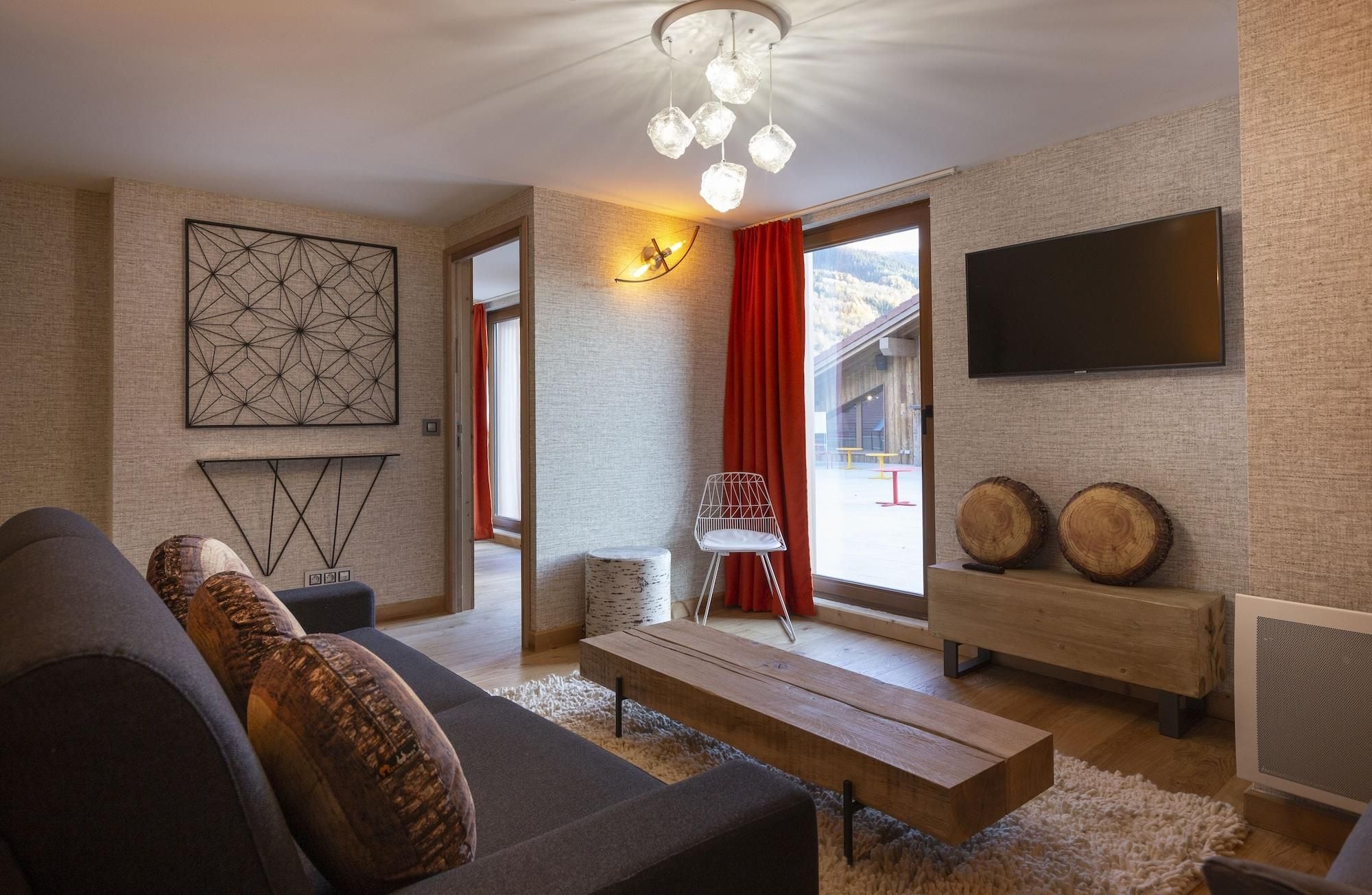A modern living room with a sofa, a coffee table, a TV, and a fireplace.