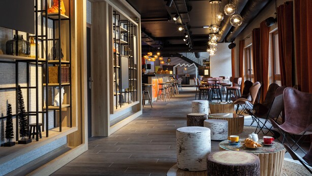 A modern interior with wooden floors, a bar area, and seating arrangements. - Base Camp Lodge (Bourg-Saint-Maurice)