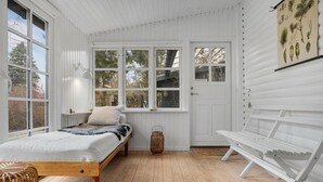Ein gemütliches Zimmer mit einem Bett, einer Bank und einem Fenster mit Blick auf einen Garten.