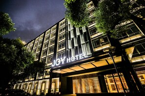 A hotel building with a prominent illuminated sign reading 'JOY HOTEL'. - Joy Hotel Hangzhou (Hangzhou)