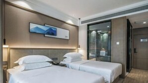 A hotel room with two beds, a large mirror, and a painting on the wall. - Joy Hotel Hangzhou (Hangzhou)