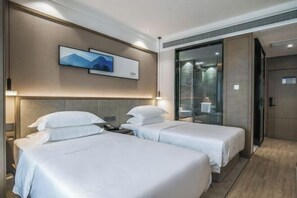 A hotel room with two beds, a large mirror, and a painting on the wall. - Joy Hotel Hangzhou (Hangzhou)