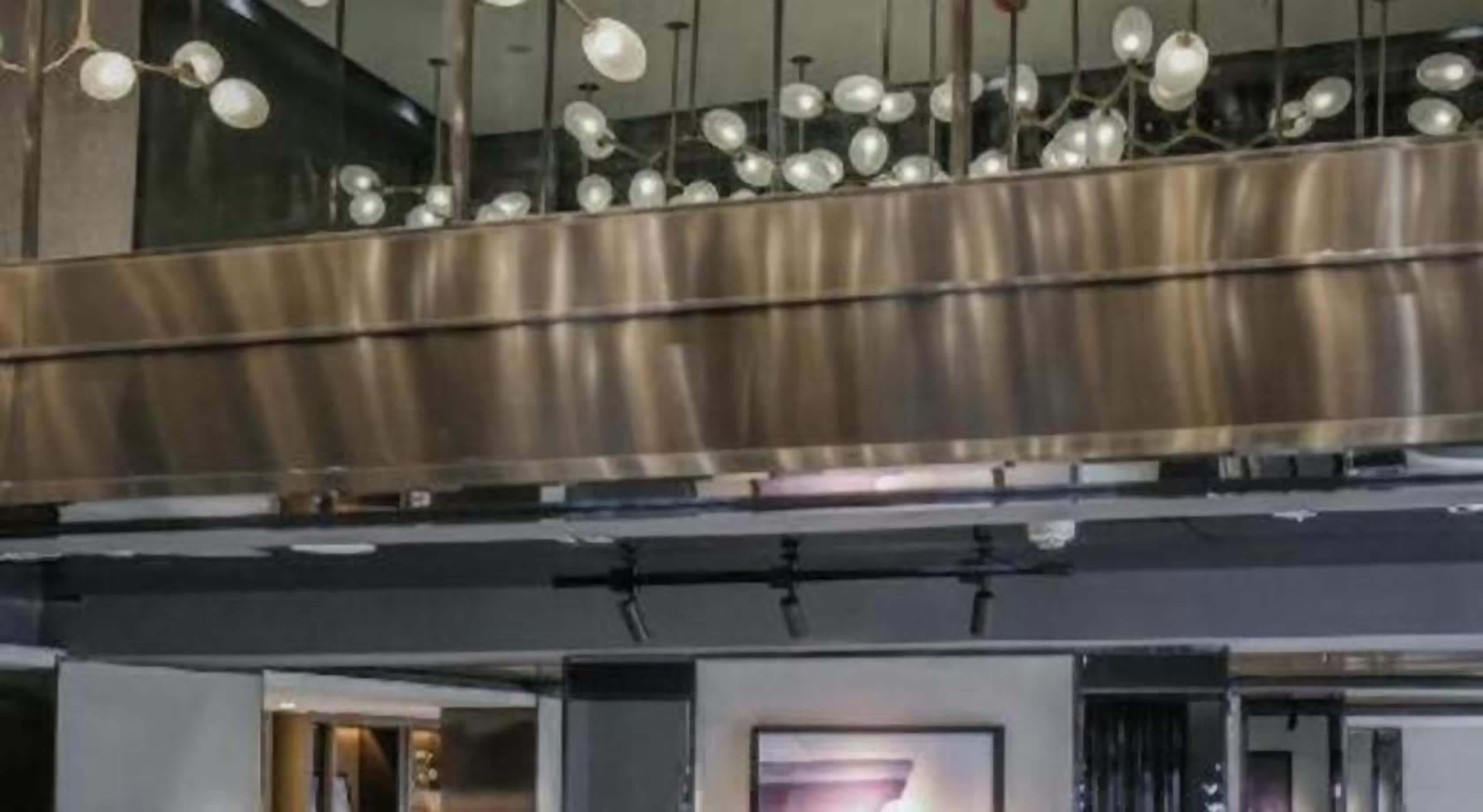 A modern interior with a metallic ceiling and pendant lighting.