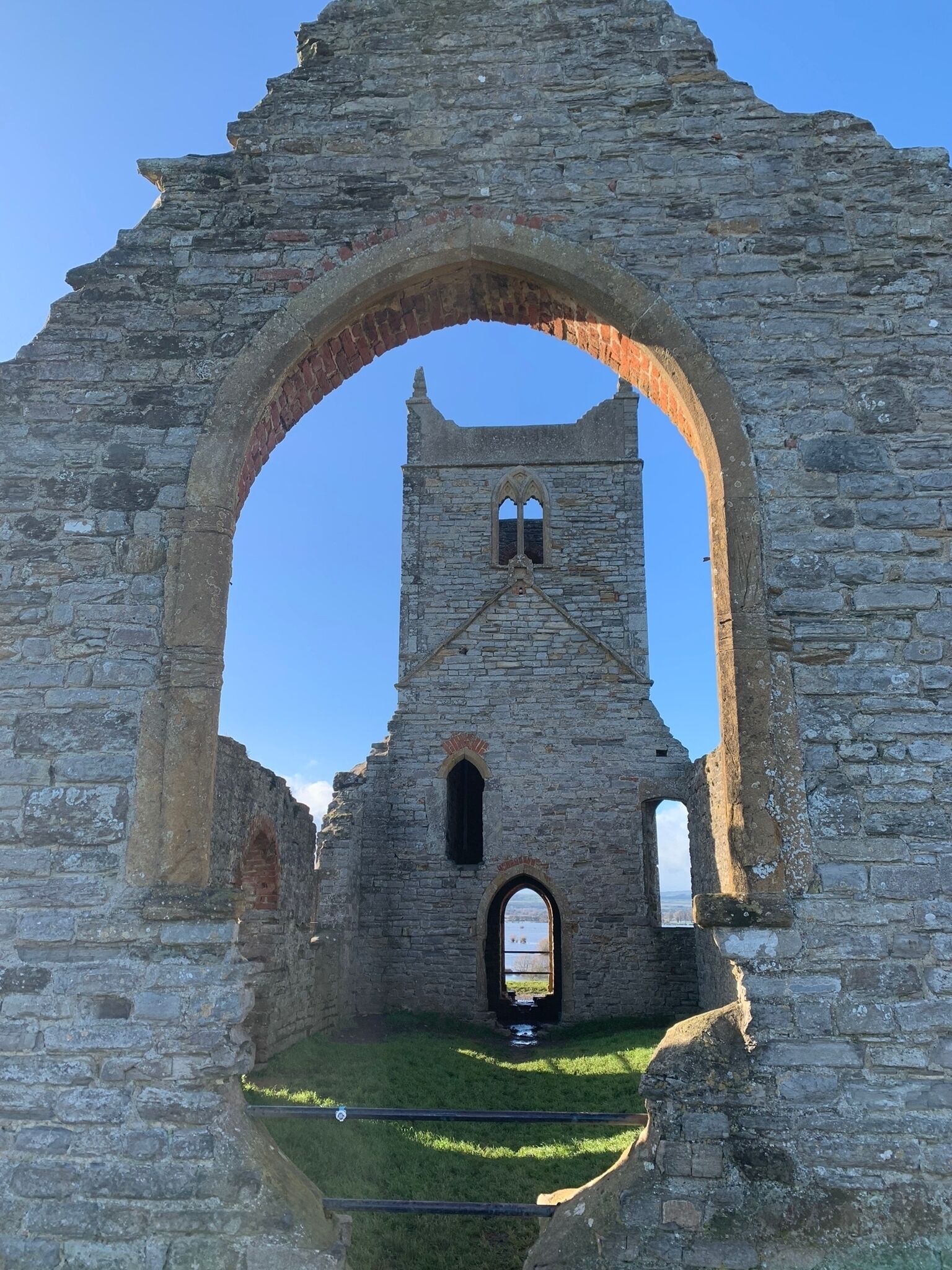 An ancient stone structure with a large archway and a tower.