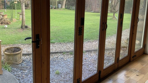 A room with large sliding glass doors leading to a garden. - River and country views & woodburner at ‘The Nest’ (Burrowbridge)
