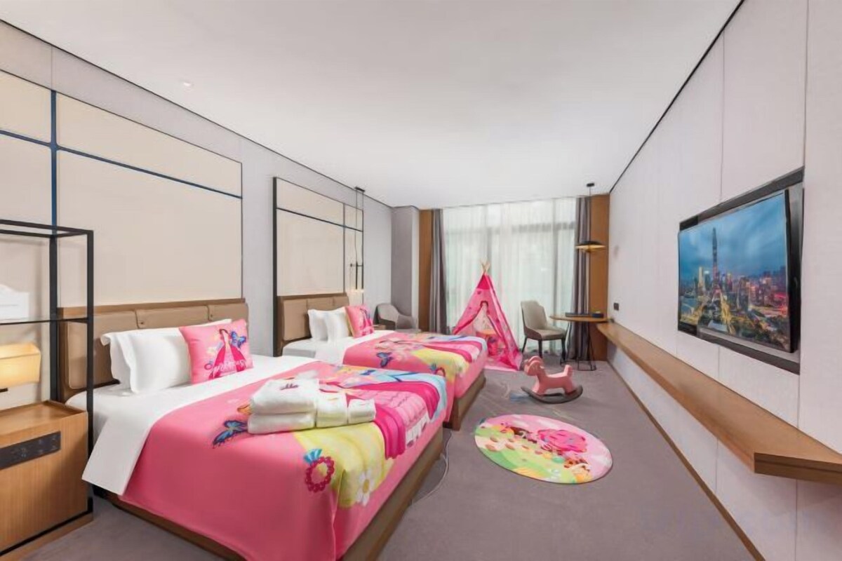 Habitació d'hotel amb un llit gran, una taula, una cadira i una televisió.