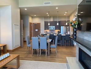 A modern kitchen with a dining area, wooden flooring, and pendant lighting. - Grand Colorado, 3 BD, master & 2 suites. Luxury Resort, steps to lifts & gondola (Breckenridge)
