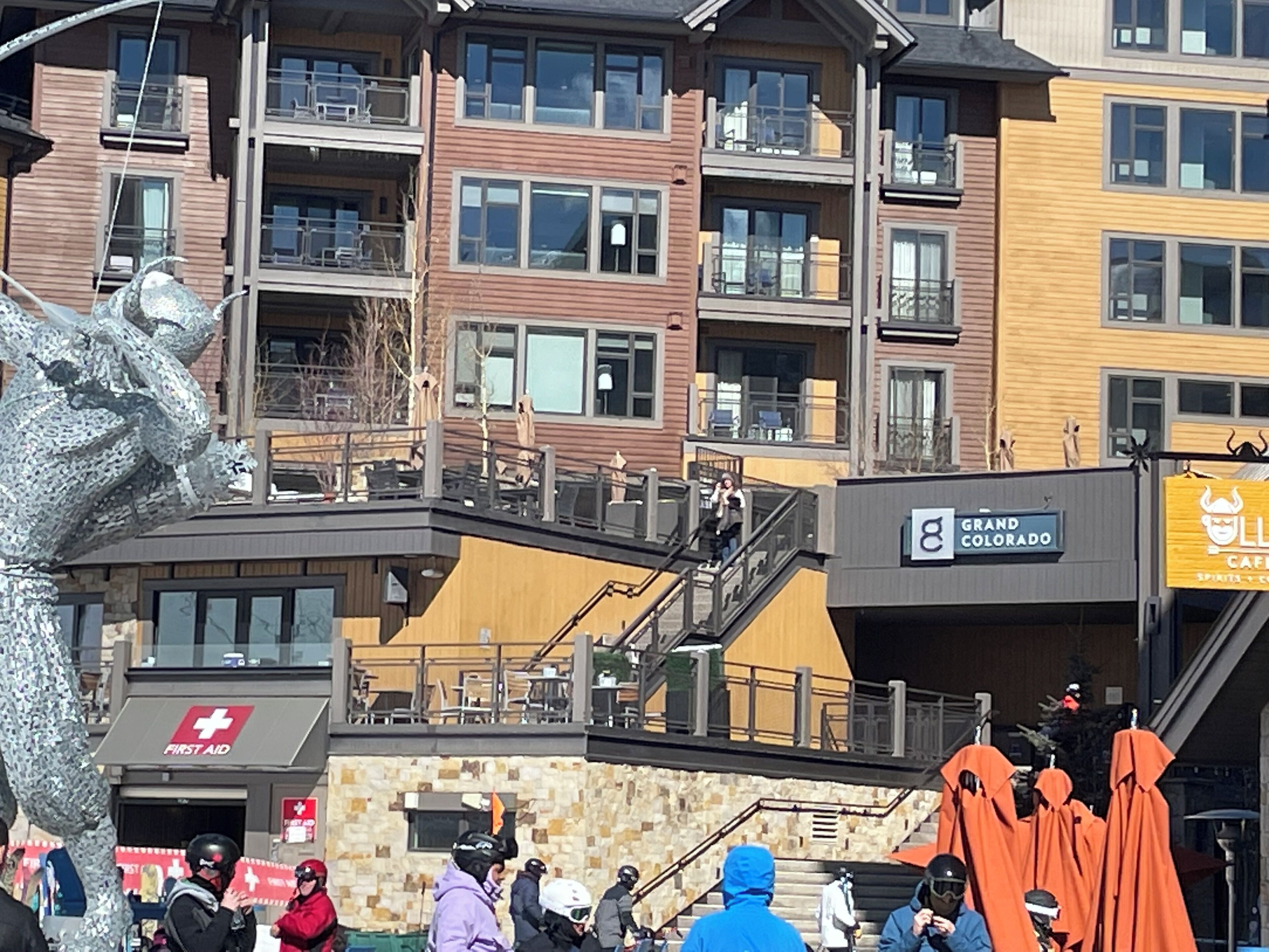 A multi-story building with balconies, a First Aid sign, and a Grand Colorado sign.