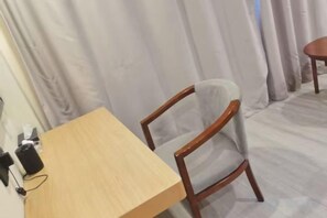 A room with a wooden table, a chair, and a curtain. - Lan'o Shangpin Hotel Xiangshuihua Never Sleeping City (Xiangshui)