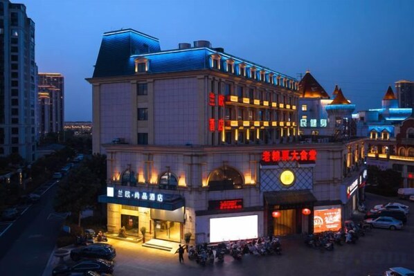 A multi-story hotel with a prominent entrance and signage. - Lan'o Shangpin Hotel Xiangshuihua Never Sleeping City (Xiangshui)