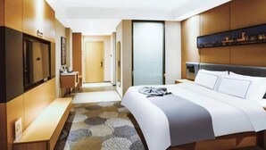 Une chambre d’hôtel avec un lit, une table de chevet et un miroir.