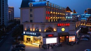 Un hôtel à plusieurs étages, une enseigne bien visible avec des caractères chinois et un grand panneau publicitaire illuminé.