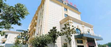 A multi-story hotel with a prominent entrance and a sign above the doors.