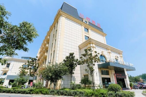 A multi-story hotel with a prominent entrance and a sign above the doors. - Lan'o Shangpin Hotel Xiangshuihua Never Sleeping City (Xiangshui)