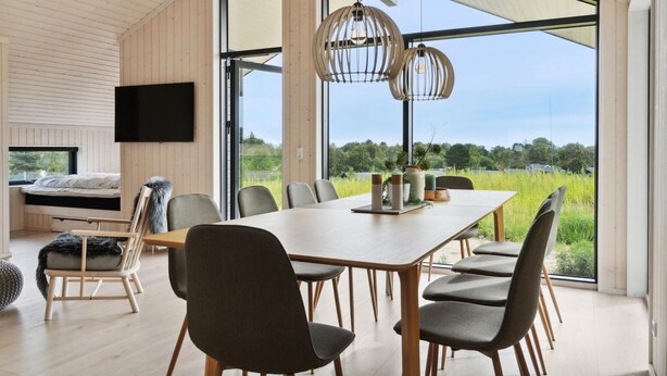 Un interno moderno con zona pranzo, un letto e una TV.