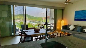 A modern kitchen with a large window, a dining area, and a sofa. - Relax in front of Ixtapa's beautiful Marina. (Ixtapa Zihuatanejo)