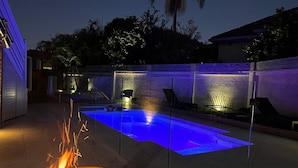 Piscina com lareira e iluminação ambiente.