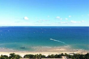 A beach with clear skies, calm sea, and distant boats. - Dadong Haiminghe Inn (Sanya)