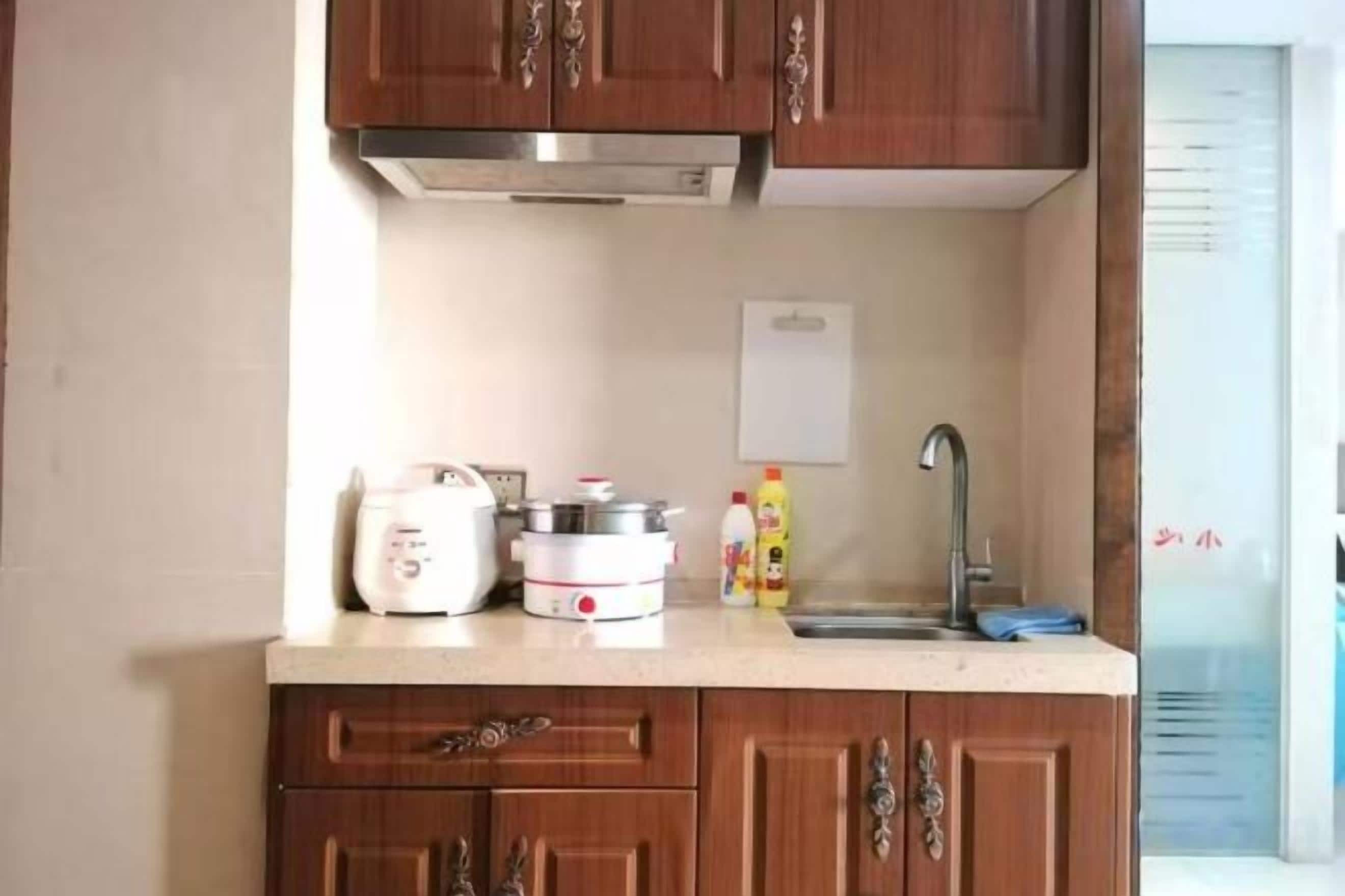 Une cuisine avec des meubles de rangement en bois, un plan de travail, un évier et une cuisinière.