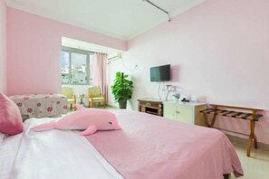 Ein Hotelzimmer mit Bett, Schreibtisch, Stuhl, Fernseher und Balkonblick.