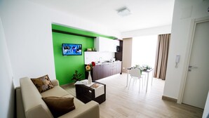 A modern living room with a sofa, coffee table, and a green accent wall. - Vignadonica Resort (Fisciano)