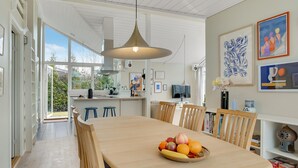 A modern kitchen with a dining area, large windows, and a fruit bowl on the table. - Awesome home in Strøby with WiFi (Strøby)