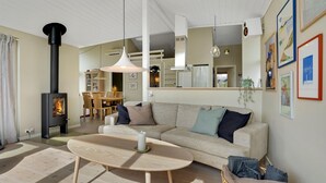 A cozy living room with a sofa, a round wooden coffee table, and a fireplace. - Awesome home in Strøby with WiFi (Strøby)