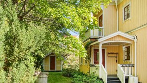 A yellow building with a porch and steps leading to a door. - Cozy home in Skutskär with sauna (Skutskär)