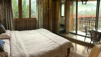A room with a bed, a window, and a balcony with chairs.