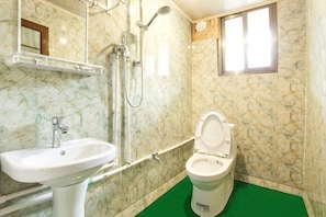 Un baño con lavabo, inodoro, ducha y ventana.