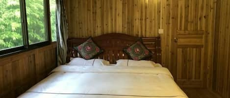Una habitación de madera con una cama, una ventana y una puerta.
