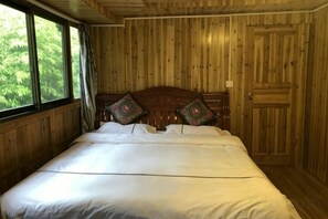 A wooden room with a bed, a window, and a door. - Xiao Bei Lou (Longsheng)