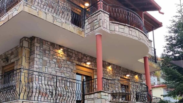 A multi-story stone building with balconies, a stone facade, and a red roof. - Αρχοντικό Δρυάδες 1 (Belokomiti)