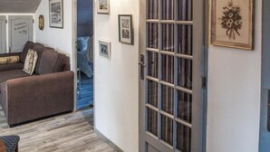 Ein gemütliches Wohnzimmer mit einem braunen Sofa, einem kleinen Tisch und einer Treppe, die zu einer anderen Ebene führt.