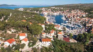An aerial view of a coastal town with a marina, surrounded by residential buildings and greenery. - Stunning apartment in Milna with WiFi (Milna)