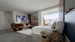 Una sala de estar moderna con un sofá, un televisor y cerámica decorativa.