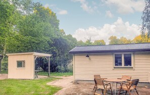 Guest house with a flat roof and single window, offering a peaceful outdoor dining area with a table and chairs.