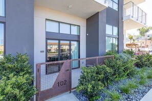 A modern building with a large glass window and a metal gate labeled "102". - NEW Modern North Park. Short Walk From Everything (San Diego)
